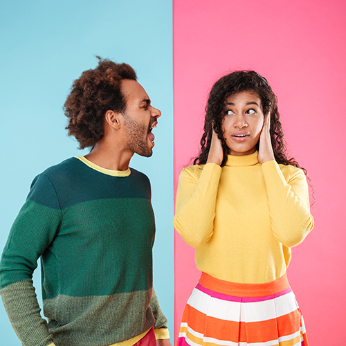 Young man speaking loudly at a young girl