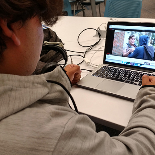 Young person seated at their computer