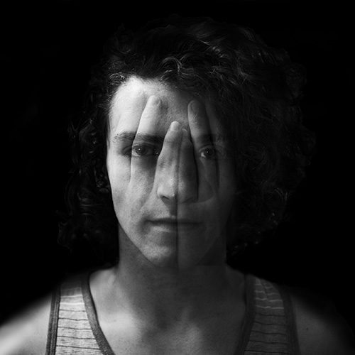 Young man portrait with hands superimposed over his face